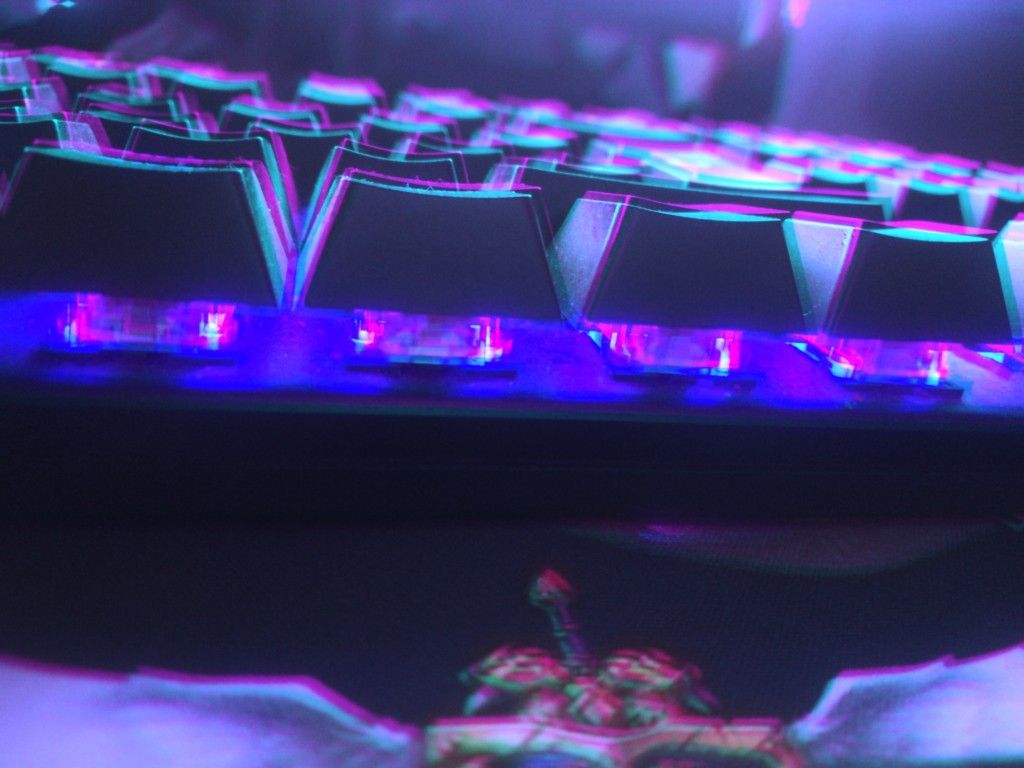 Close-up of a mechanical keyboard glowing cyan, violet, and magenta